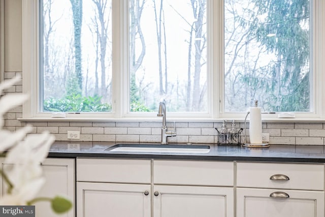 interior details with white cabinetry and sink