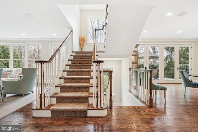 stairway with french doors and hardwood / wood-style flooring