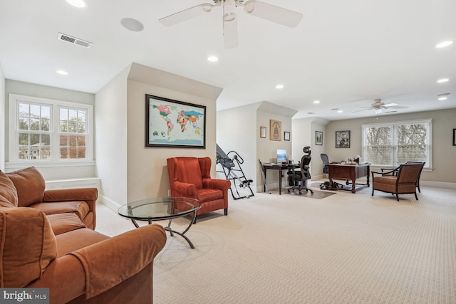 carpeted living room featuring ceiling fan and a wealth of natural light