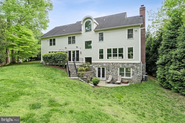 back of house with central air condition unit, a patio area, and a yard