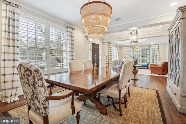 dining room with crown molding, a healthy amount of sunlight, dark hardwood / wood-style floors, and a notable chandelier