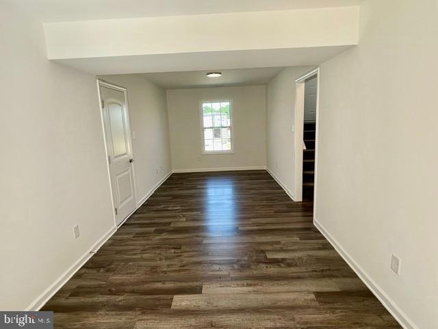 empty room with dark hardwood / wood-style floors