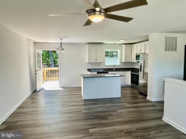 kitchen with stainless steel appliances, ceiling fan, sink, decorative light fixtures, and white cabinetry