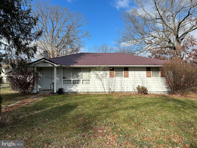 view of front of property with metal roof, a front lawn, and a chimney