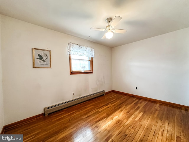 spare room featuring ceiling fan, a baseboard radiator, wood-type flooring, and baseboards