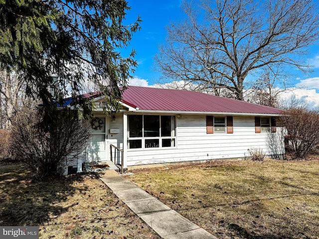 ranch-style house featuring metal roof and a front lawn