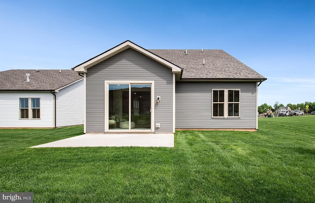 rear view of property with a lawn and a patio