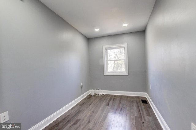 unfurnished room with dark wood-style floors, visible vents, recessed lighting, and baseboards