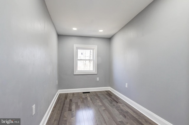 spare room with dark wood-style floors, recessed lighting, and baseboards