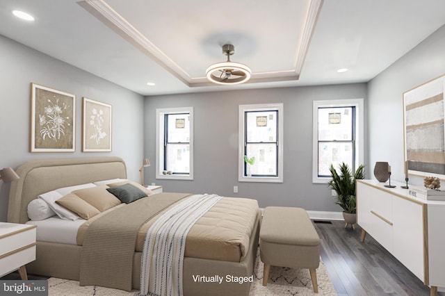 bedroom with a raised ceiling, recessed lighting, dark wood-type flooring, and baseboards