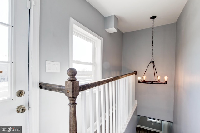 stairway featuring a chandelier