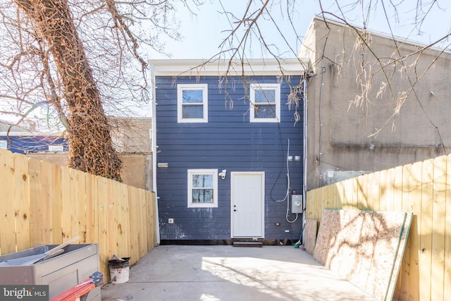 rear view of property featuring a patio area and fence