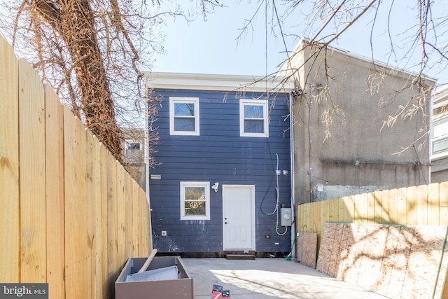 rear view of house with a patio area and fence