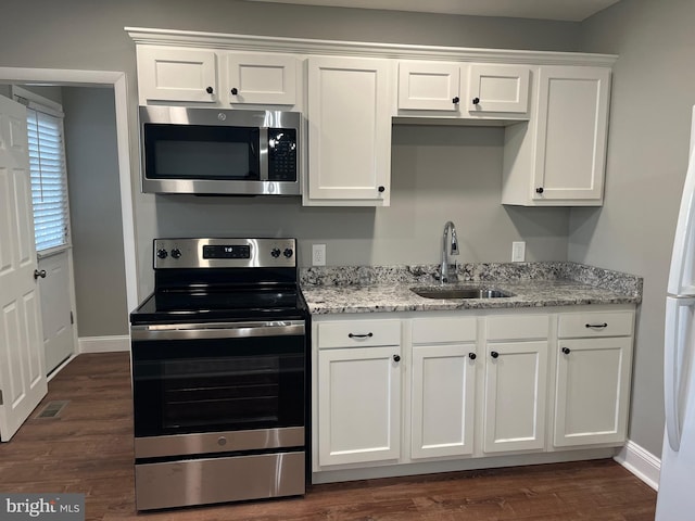 kitchen with white cabinets, stainless steel appliances, light stone countertops, and sink