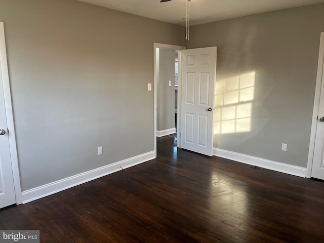 spare room with ceiling fan and dark hardwood / wood-style flooring