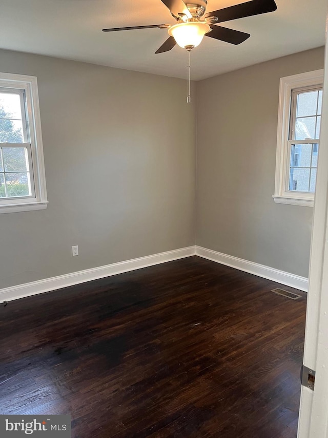 spare room with dark hardwood / wood-style flooring and ceiling fan