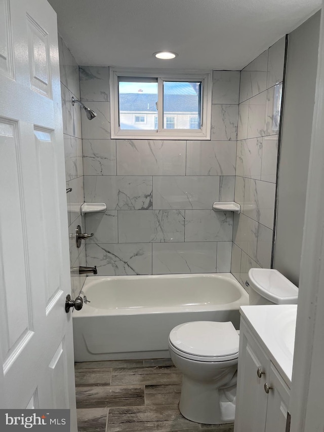 full bathroom with hardwood / wood-style floors, vanity, toilet, and tiled shower / bath