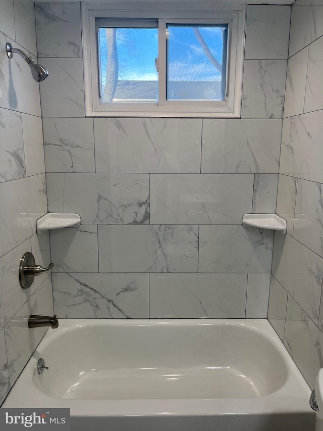 bathroom featuring tiled shower / bath