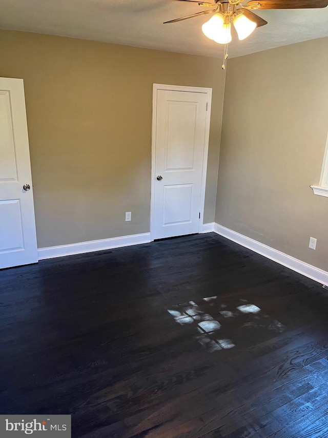 empty room featuring dark hardwood / wood-style flooring and ceiling fan