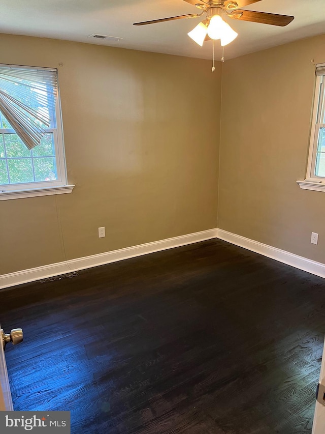 empty room with ceiling fan and dark wood-type flooring