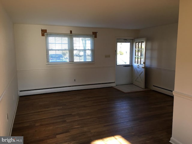 interior space with baseboard heating, dark hardwood / wood-style flooring, and a healthy amount of sunlight