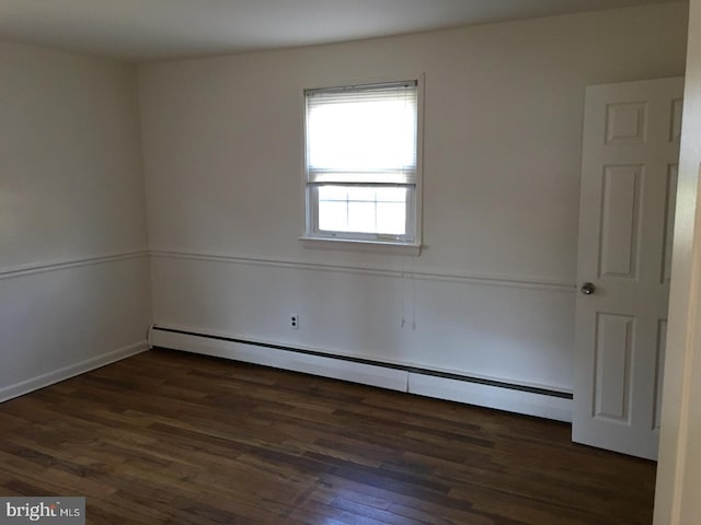 spare room with dark hardwood / wood-style flooring and a baseboard radiator