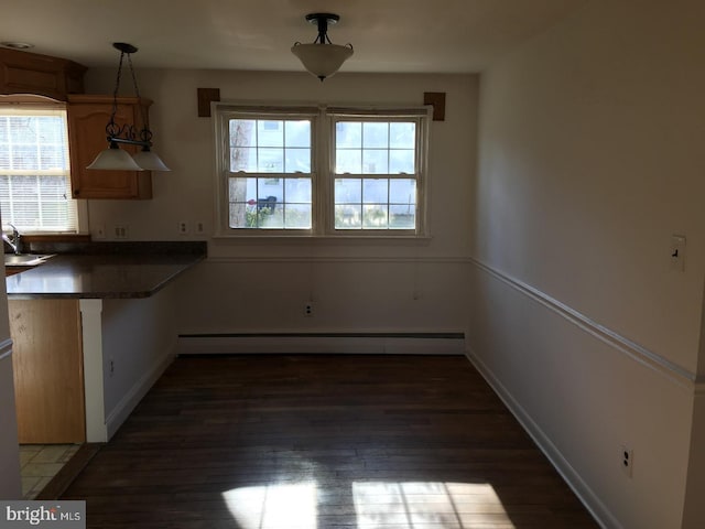 kitchen featuring baseboard heating, kitchen peninsula, a wealth of natural light, and pendant lighting