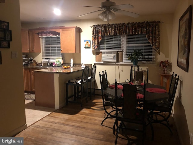 dining room with light wood-type flooring, ceiling fan, and cooling unit