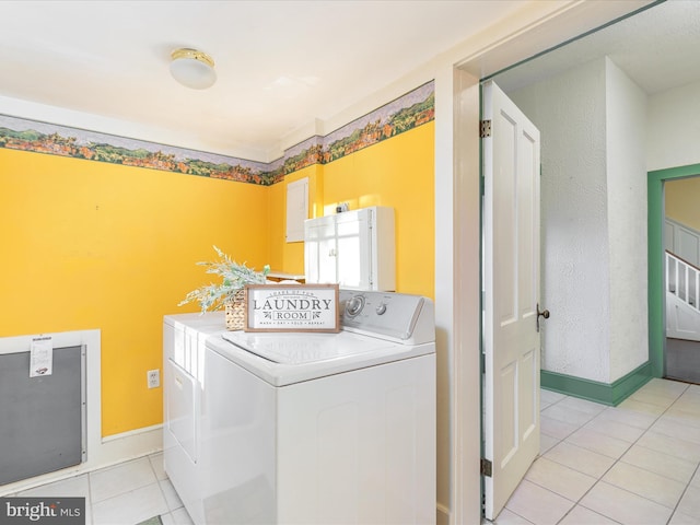 clothes washing area featuring light tile patterned floors and washing machine and dryer