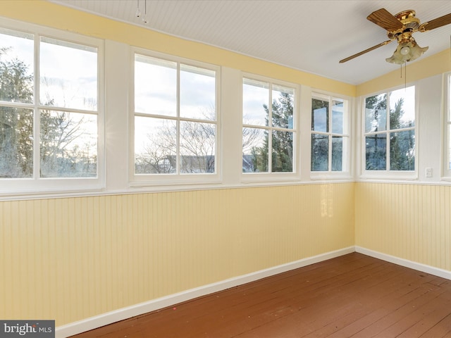 unfurnished sunroom with ceiling fan