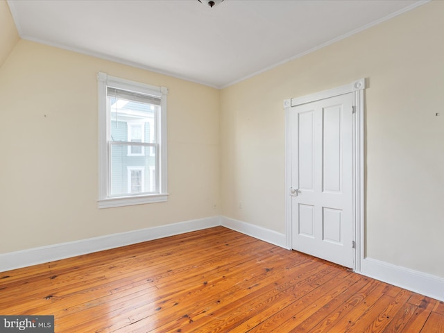 spare room with wood-type flooring and ornamental molding