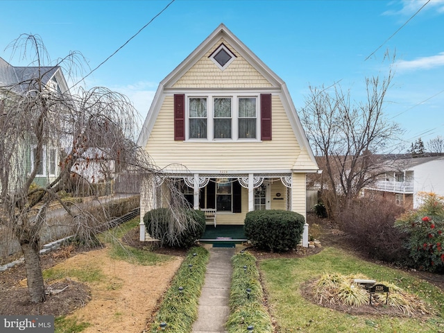 view of front facade featuring covered porch and a front lawn