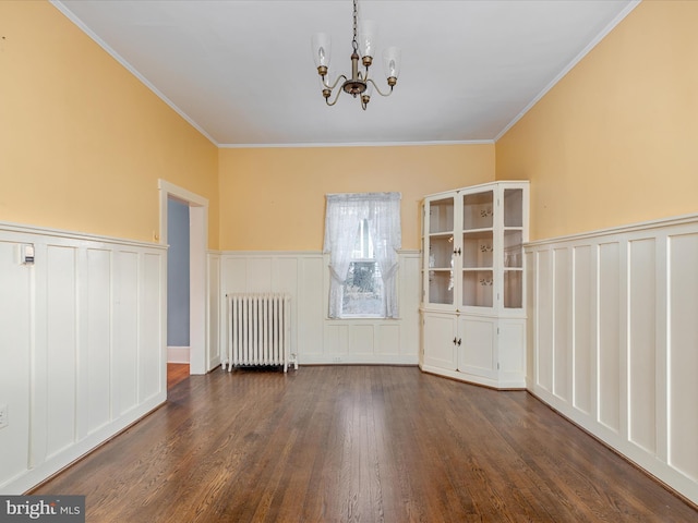 unfurnished room featuring dark hardwood / wood-style floors, an inviting chandelier, radiator, and crown molding