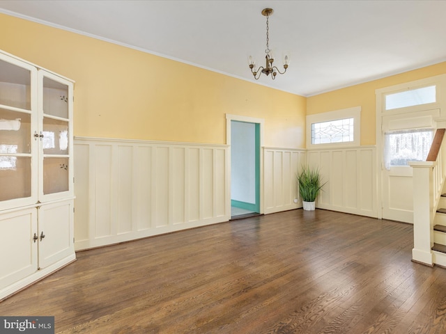 unfurnished room featuring dark wood-type flooring and a notable chandelier