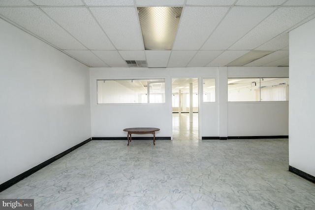 unfurnished room featuring a drop ceiling