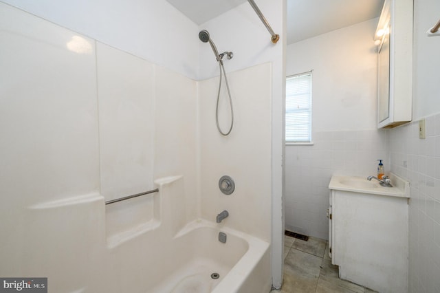 bathroom featuring shower / tub combination, vanity, tile patterned floors, and tile walls