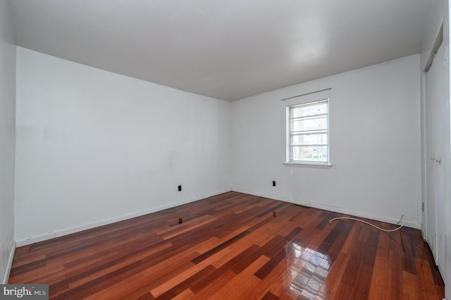 unfurnished room with dark wood-type flooring