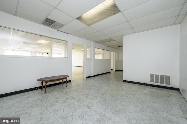 basement with a paneled ceiling