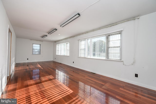 empty room with dark hardwood / wood-style flooring