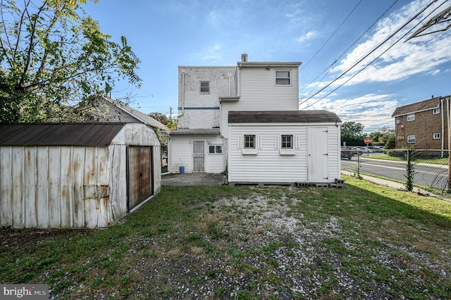 rear view of property with a yard and a storage shed