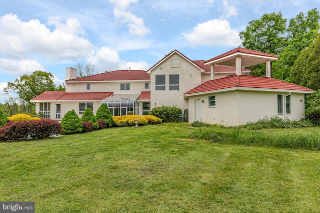 back of property with a lawn and a lanai