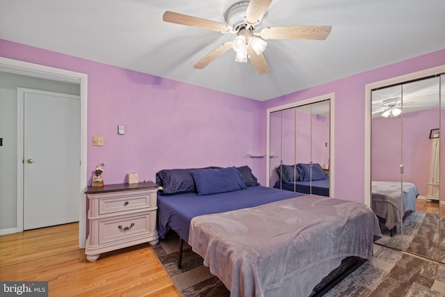 bedroom with multiple closets, hardwood / wood-style floors, and ceiling fan