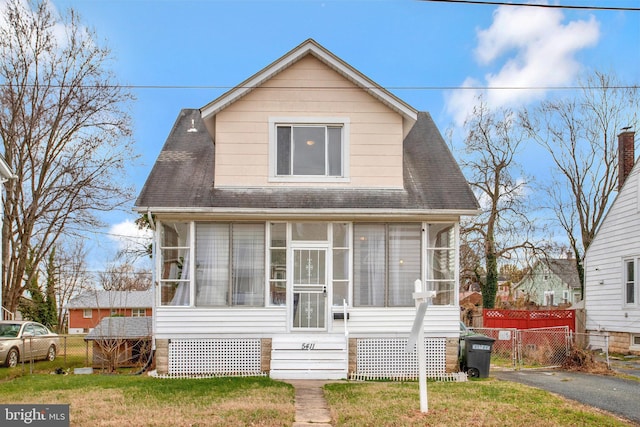 bungalow with a sunroom and a front lawn