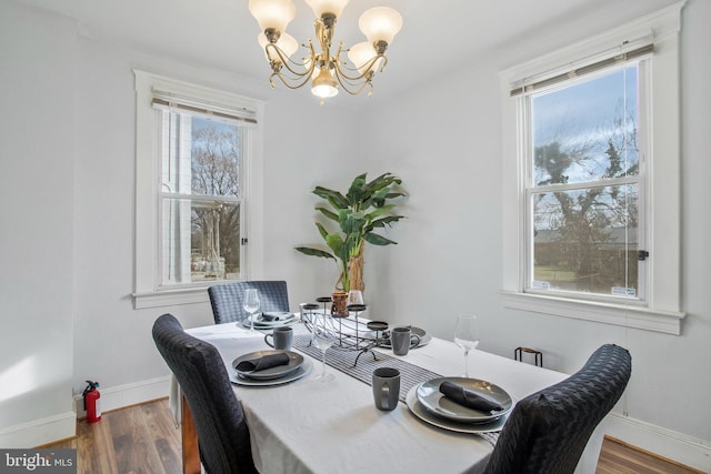 dining area with dark hardwood / wood-style floors and a notable chandelier