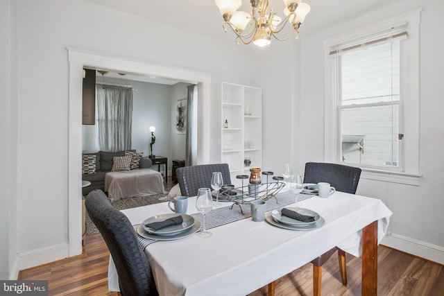 dining space featuring dark hardwood / wood-style flooring and an inviting chandelier