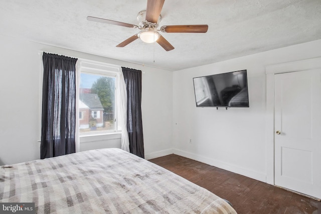 bedroom featuring a textured ceiling, ceiling fan, and dark hardwood / wood-style floors