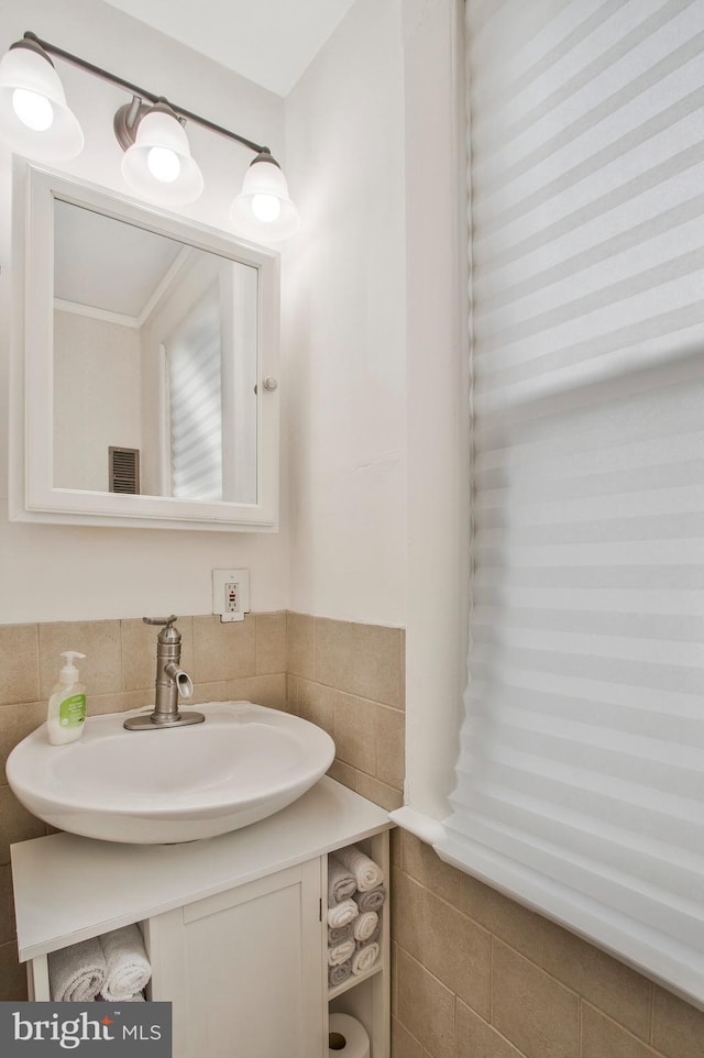 bathroom featuring sink and tile walls