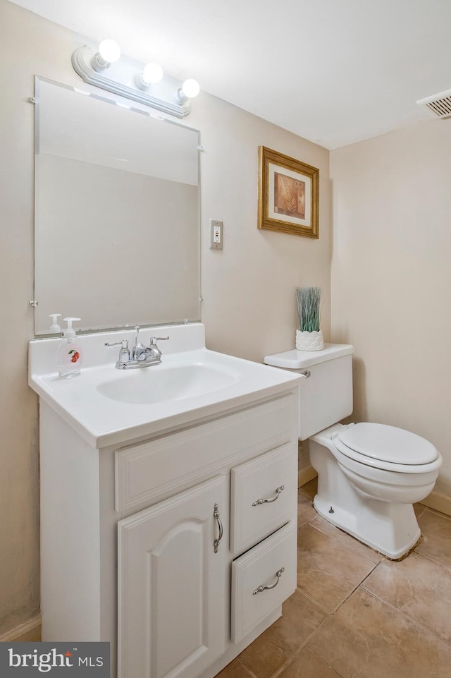 bathroom with tile patterned flooring, vanity, and toilet