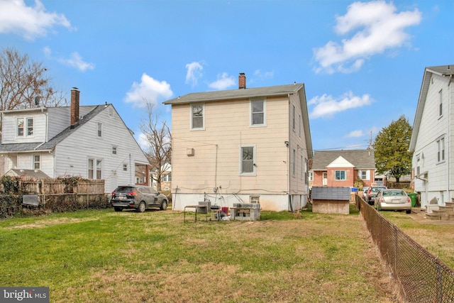 back of house featuring a lawn