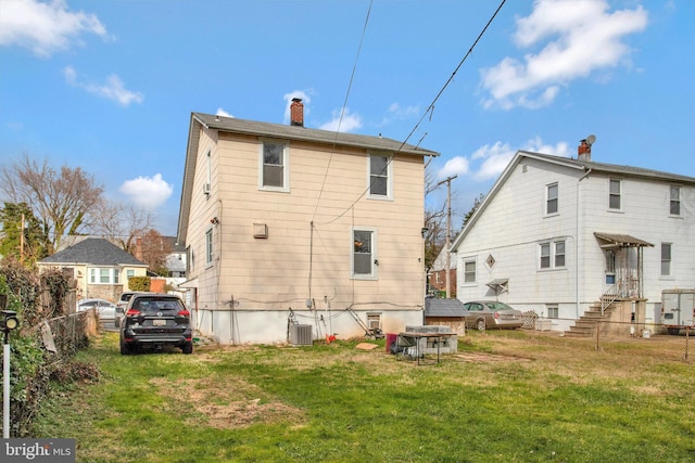 rear view of property with a yard and cooling unit